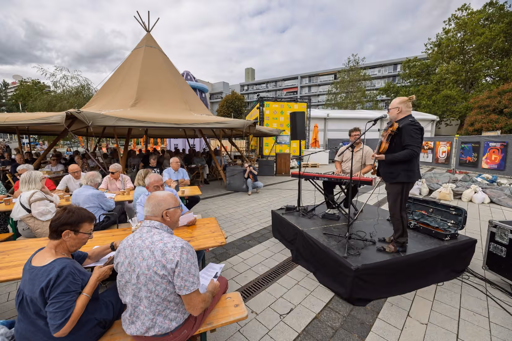 Bezoekers luisteren naar een muzikant tijdens de koffietafel